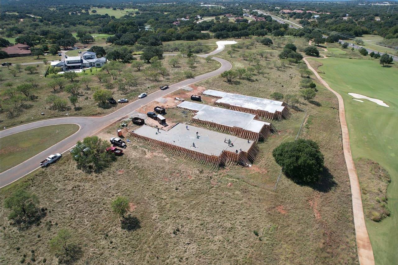 Aerial view of a large reinforced concrete building pad poured near a golf course