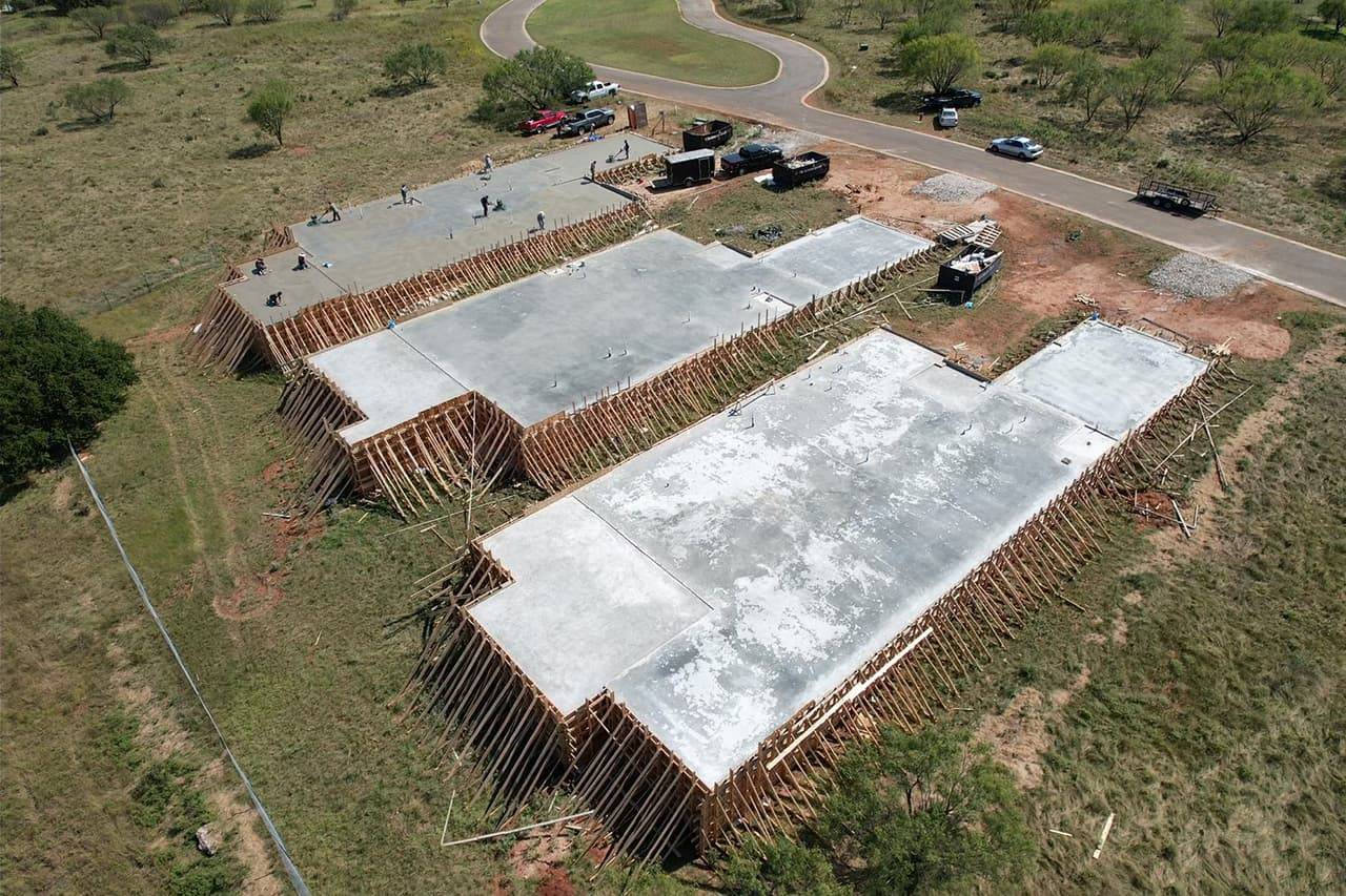 Close aerial view of a large reinforced concrete building pad formed and poured
